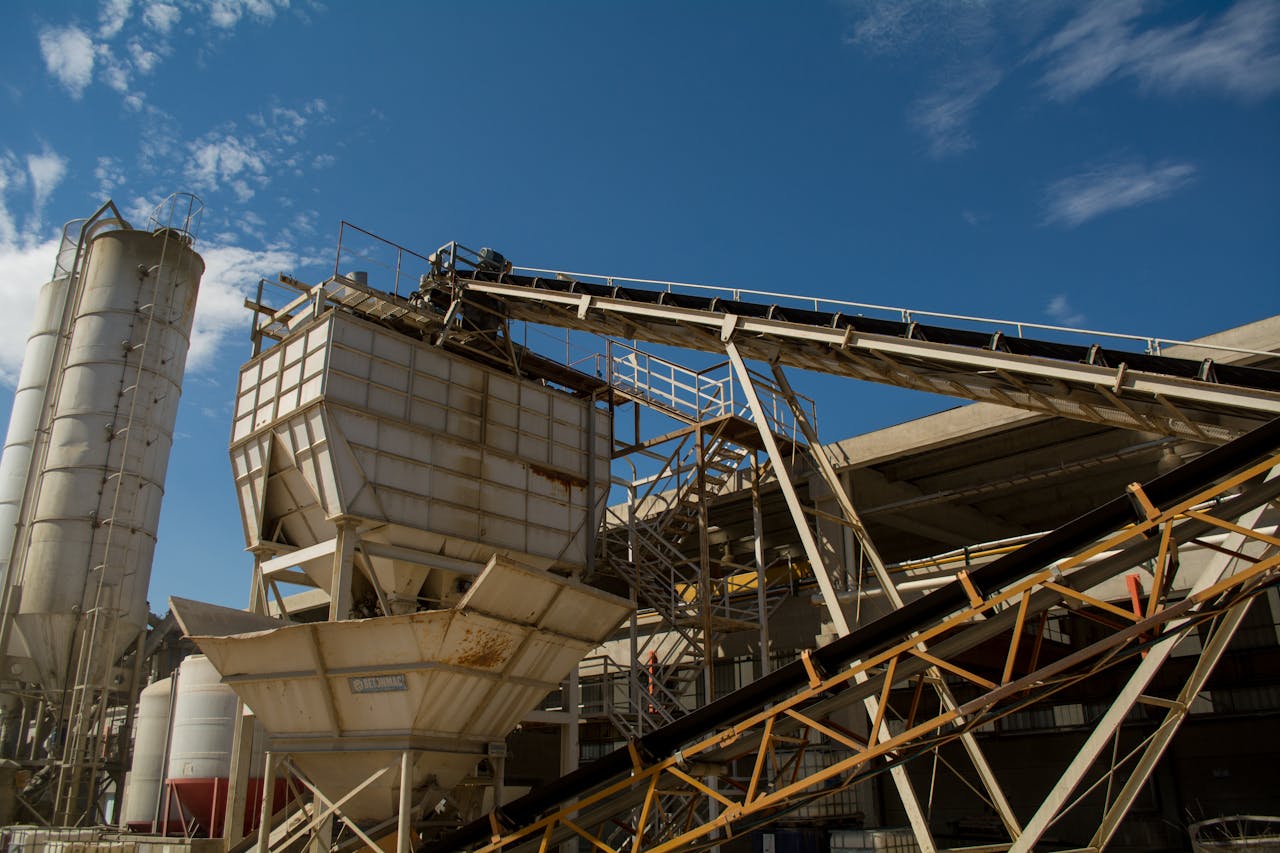 View of rusty machinery and structures at an industrial plant in Córdoba under a clear blue sky.